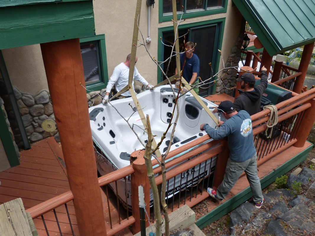men installing hot tub on deck